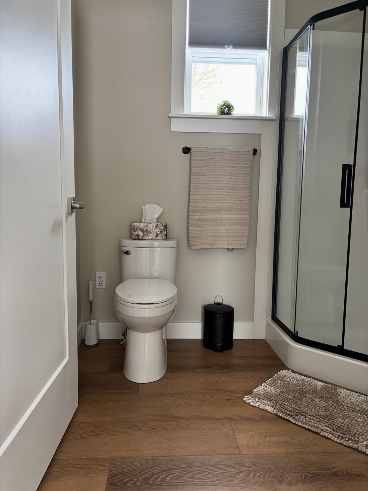 Bright bathroom with black-framed shower at The Carriage House